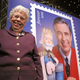 Fred Rogers wife, Mrs. Joanne Rogers poses in front a poster of the Mister Rogers Forever Stamp following the first-day-of-issue dedication in WQED’s Fred Rogers Studio in Pittsburgh, Friday, March 23, 2018